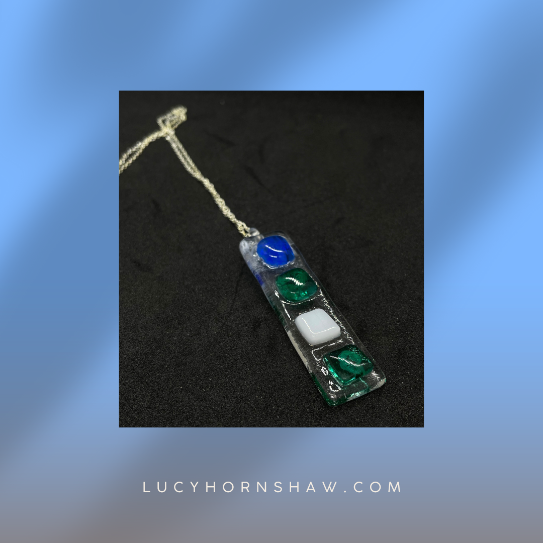 Fused clear glass with blue, green, and white squares oblong necklace