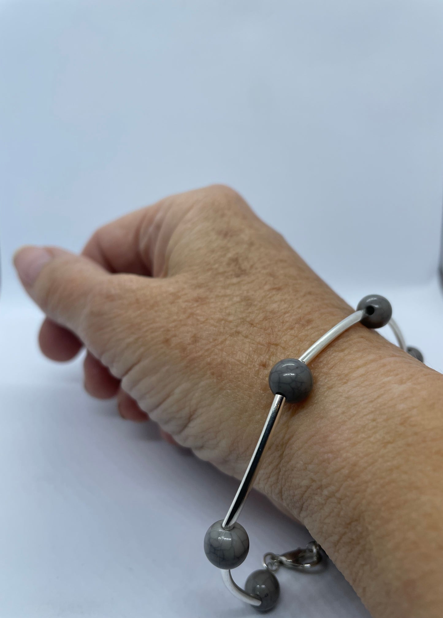 Wire & grey bead bracelet with silver rod spacers