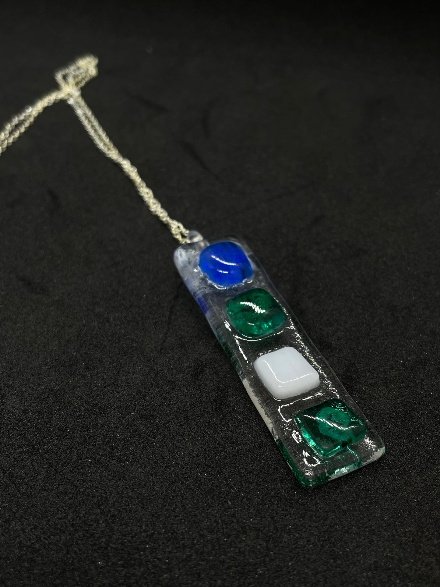 Fused clear glass with blue, green, and white squares oblong necklace