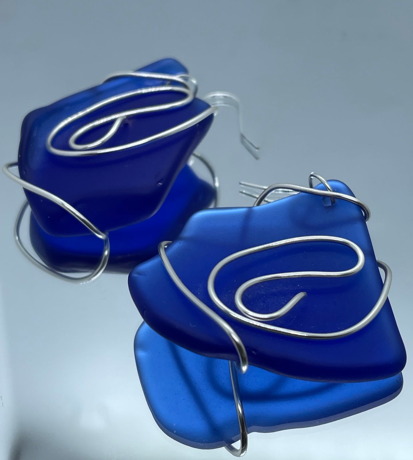 Blue Seaglass entwined in silver wire twists drop earrings