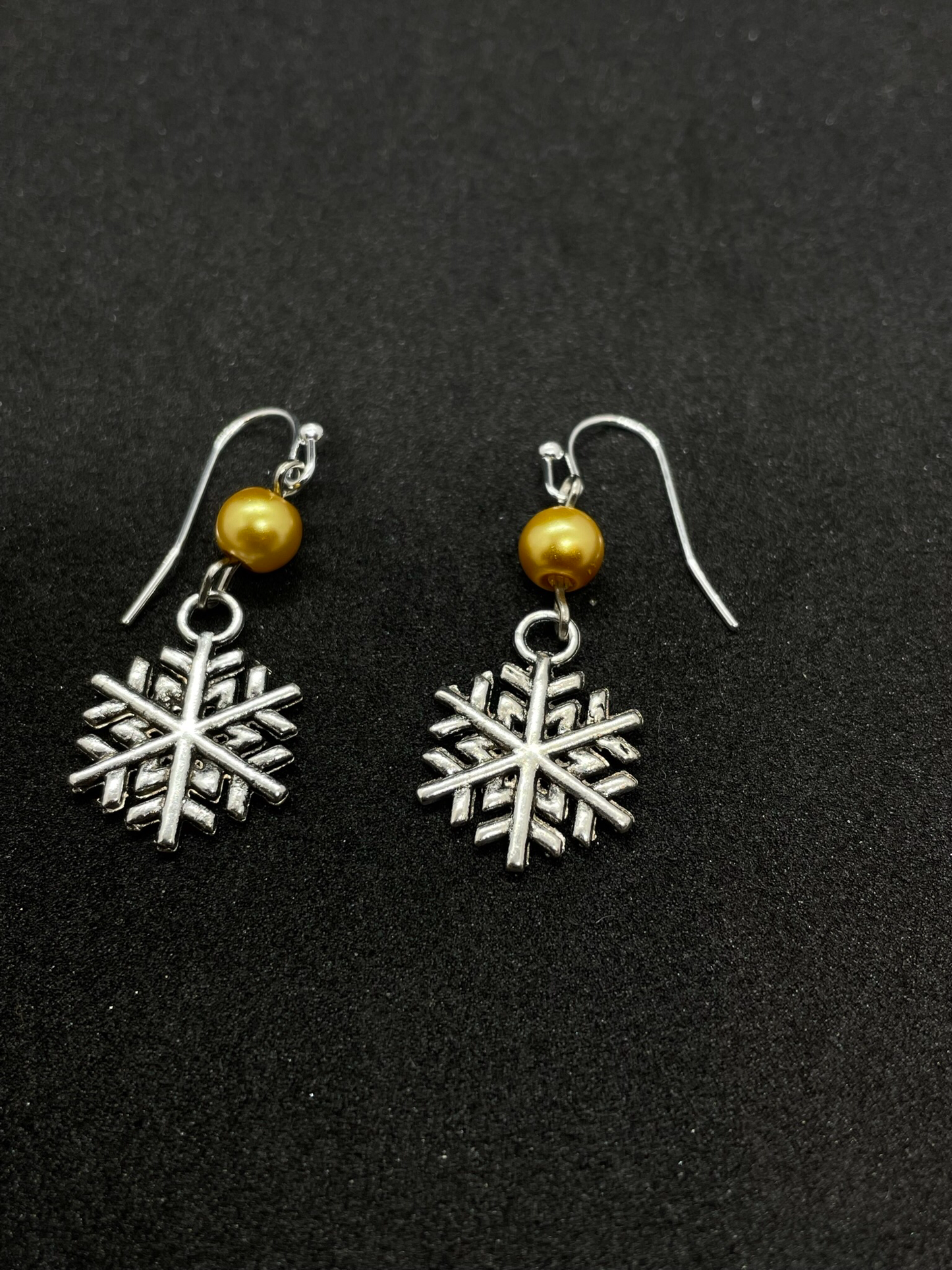 Festive snowflake dangling from bead, drop earrings