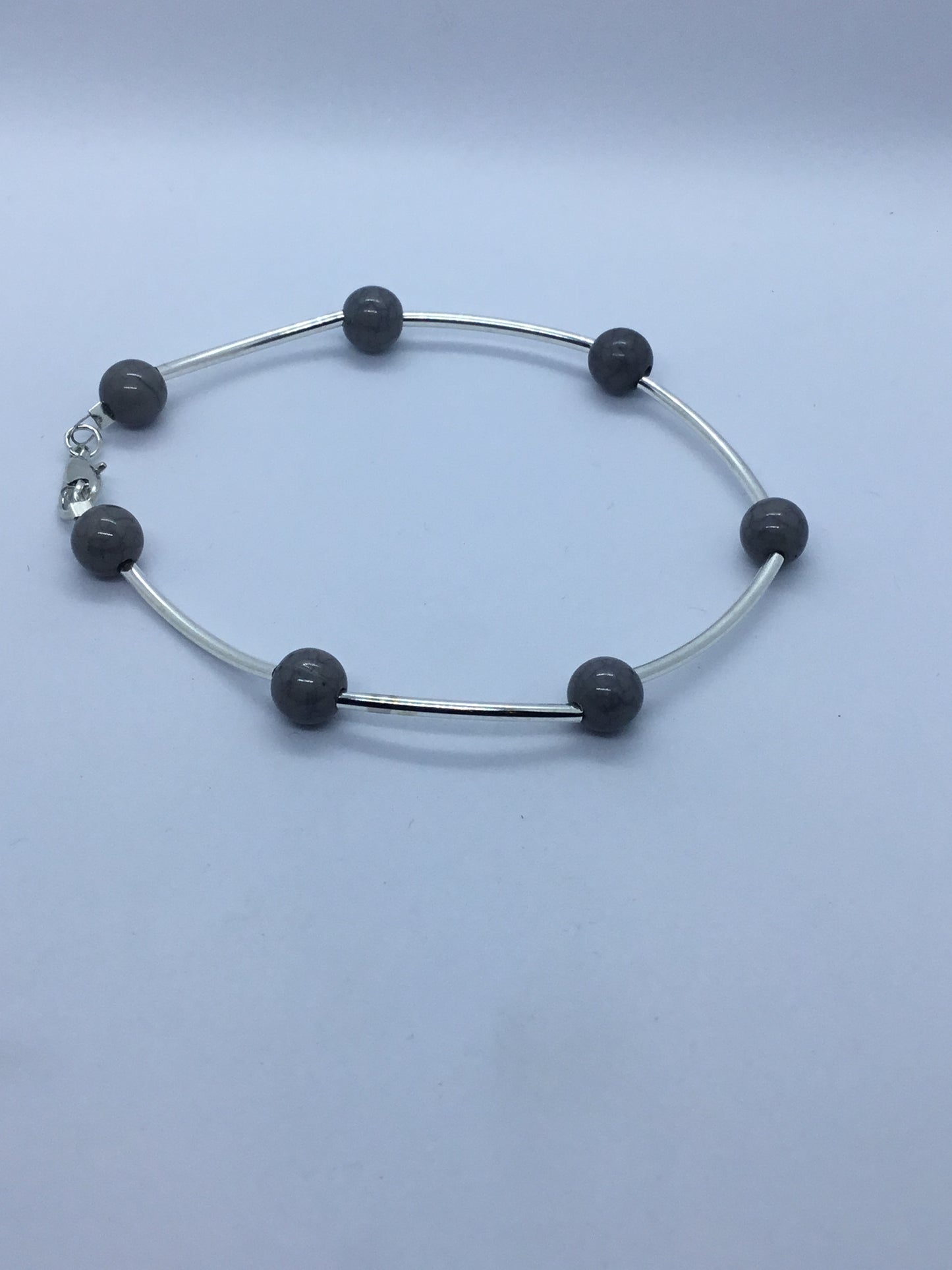 Wire & grey bead bracelet with silver rod spacers